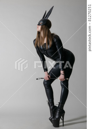 Sexy beautiful woman pole dancer posing in latex costumen background. Easter bunny concept. Sexy beautiful woman pole dancer posing in latex costumen background. Easter bunny concept. 81270251