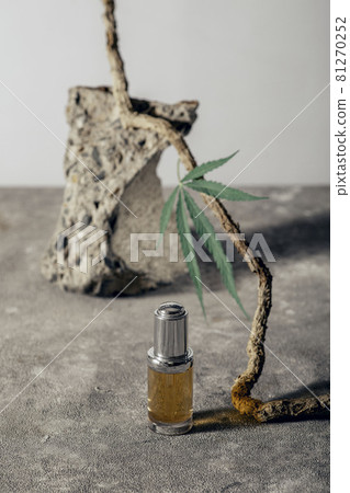 Glass bottle with CBD oil, THC tincture and hemp leaf on gray marble background. naturalness. CBD oil cosmetics. Glass bottle with CBD oil, THC tincture and hemp leaf on gray marble background. naturalness. CBD oil cosmetics. 81270252