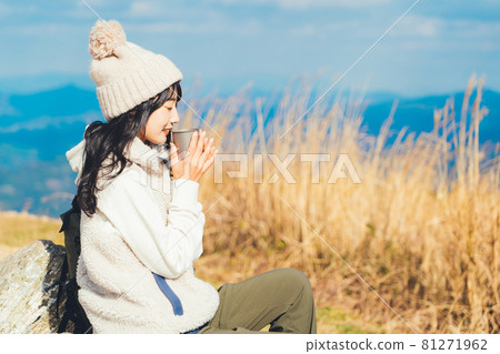 Woman drinking coffee at the top of the mountain 81271962