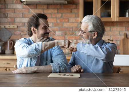 Smiling adult son and old dad play board game 81273045