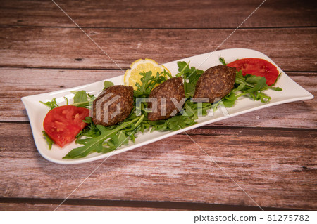 Traditional kebbe and pita bread on big round plate in lebanese restaurant Traditional kebbe and pita bread on big round plate in lebanese restaurant 81275782