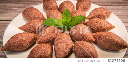 Traditional kebbe and pita bread on big round plate in lebanese restaurant Traditional kebbe and pita bread on big round plate in lebanese restaurant 81275806
