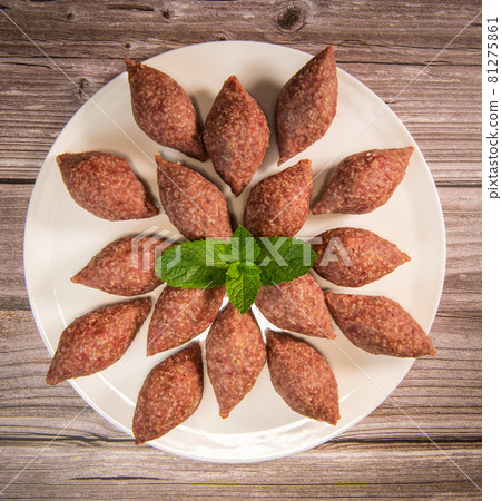 Traditional kebbe and pita bread on big round plate in lebanese restaurant Traditional kebbe and pita bread on big round plate in lebanese restaurant 81275861