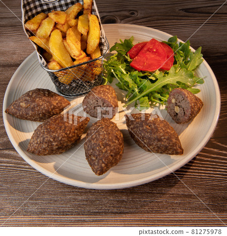 Traditional kebbe and pita bread on big round plate in lebanese restaurant 81275978