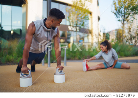 Man and woman couple friends doing workout exercise outdoors in city, talking. Man and woman couple friends doing workout exercise outdoors in city, talking. 81275979