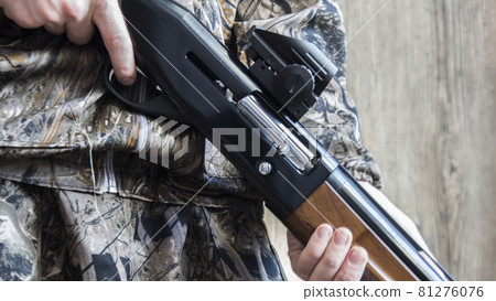 12-gauge rounds and a camo shotgun. 12-gauge rounds and a camo shotgun. 81276076