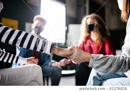 Men and women sitting in circle during group therapy, holding hands. Coronavirus concept. Men and women sitting in circle during group therapy, holding hands. Coronavirus concept. 81276858