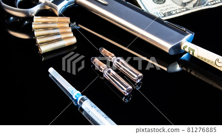Five dollars in a pistol on a black table with a syringe and cartridges.Sale, possession and distribution of drugs. Problems of youth with drug addiction,law and crime.Drug trafficking, drug cartels. Five dollars in a pistol on a black table with a syringe and cartridges.Sale, possession and distribution of drugs. Problems of youth with drug addiction,law and crime.Drug trafficking, drug cartels. 81276885