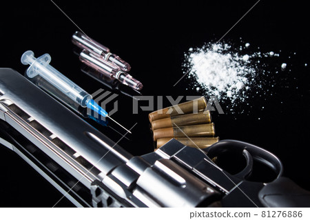 A syringe with an open needle lies on the table next to the drugs and the gun. A pistol with bullets, syringe and drugs lie on the black table. Sale, possession and distribution of drugs today A syringe with an open needle lies on the table next to the drugs and the gun. A pistol with bullets, syringe and drugs lie on the black table. Sale, possession and distribution of drugs today 81276886