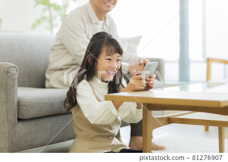 Daughter and father looking at smartphone Daughter and father looking at smartphone 81276907