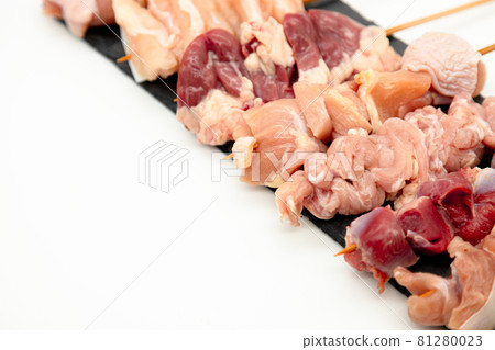 Raw yakitori lined up on a black plate 81280023