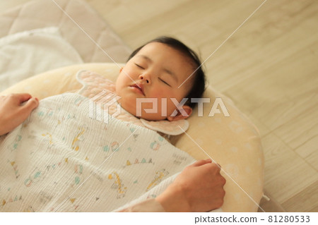 Toddler taking a nap indoors 81280533