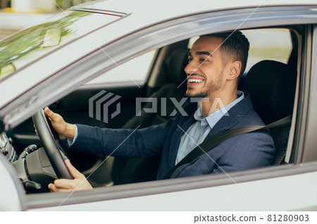 Joyful middle-eastern businessman driving his new auto Joyful middle-eastern businessman driving his new auto 81280903