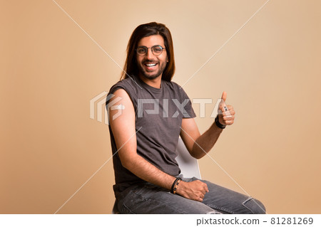 Cheerful indian guy showing thumb up, got vaccinated against COVID-19 Cheerful indian guy showing thumb up, got vaccinated against COVID-19 81281269