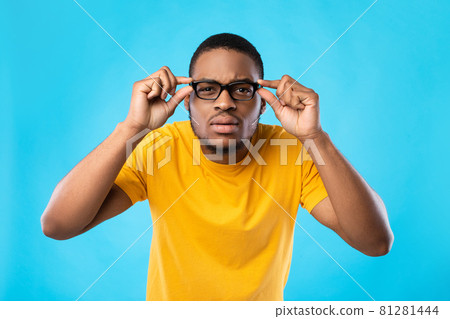 Black Guy In Glasses Squinting Eyes Posing Over Blue Background Black Guy In Glasses Squinting Eyes Posing Over Blue Background 81281444