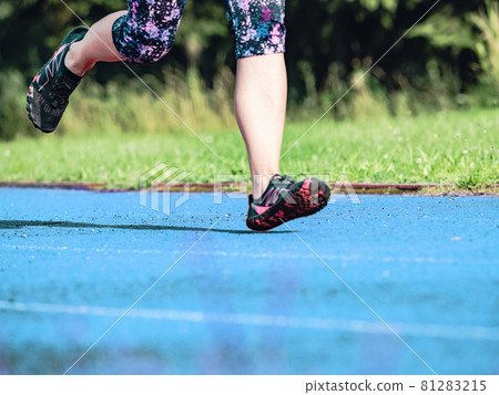 Mature asian woman in flowered up knees leggings  running along track 81283215