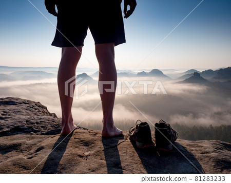 Slim male legs in strong backlight. Barefoot man hiker feet climbing Slim male legs in strong backlight. Barefoot man hiker feet climbing 81283233