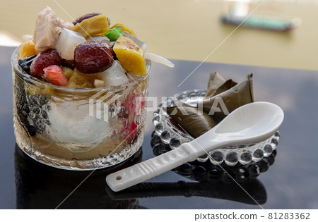 Traditional chinese iced sweet dessert is delicious here are many grains Topping with boil sugar syrup in Glass bowl. Traditional chinese iced sweet dessert is delicious here are many grains Topping with boil sugar syrup in Glass bowl. 81283362