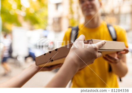 Close-up deliveryman delivers order to young girl, buyer. Work, career, different professions concept. Idea of convenience, speed, comfort, safety, service. Close-up deliveryman delivers order to young girl, buyer. Work, career, different professions concept. Idea of convenience, speed, comfort, safety, service. 81284336