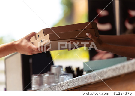 Close-up hands of deliveryman delivers order to clients, customers, buyers. Work, career, different professions concept. Idea of convenience, speed, comfort, safety, service. Close-up hands of deliveryman delivers order to clients, customers, buyers. Work, career, different professions concept. Idea of convenience, speed, comfort, safety, service. 81284370