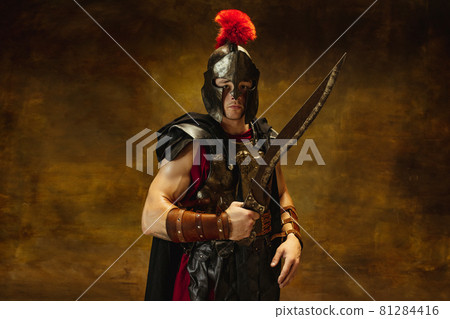 Close up of medieval person, brutal man, warrior or knight in war equipment isolated on vintage dark background. Comparison of eras, art, history, retro style concept Close up of medieval person, brutal man, warrior or knight in war equipment isolated on vintage dark background. Comparison of eras, art, history, retro style concept 81284416