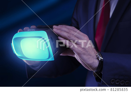 Virtual glasses in the hands of a business man on a dark background close up Virtual glasses in the hands of a business man on a dark background close up 81285835