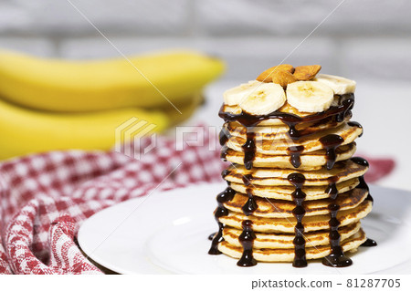 Pancakes with Chocolate Syrup, Nuts and Bananas. Stack of whole flapjack. Tasty breakfast and Healthy Food Pancakes with Chocolate Syrup, Nuts and Bananas. Stack of whole flapjack. Tasty breakfast and Healthy Food 81287705