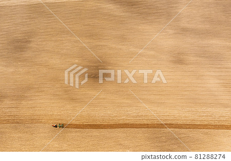 Tractor Plowing Field In Spring. Beginning Of Agricultural Season. Cultivator Pulled By A Tractor In Countryside Rural Field. Countryside Field Landscape. Aerial View. Top Flat View 81288274