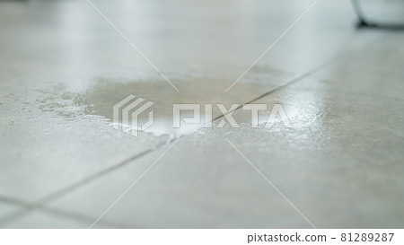 Water drips onto the tiled floor. 81289287