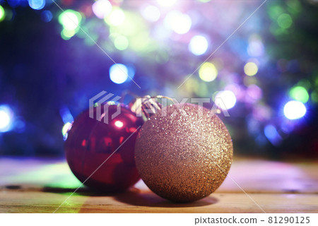 Bright and colorful Christmas tree baubles on wooden board over decorated Xmas tree Bright and colorful Christmas tree baubles on wooden board over decorated Xmas tree 81290125