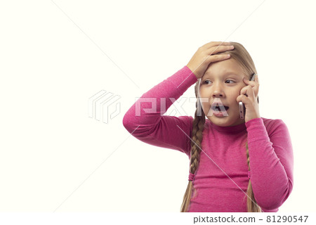 The girl is talking on the phone. Beautiful excited surprised little girl having conversation with friends mobile phone isolated on white background. Surprised emotions human face expressions. The girl is talking on the phone. Beautiful excited surprised little girl having conversation with friends mobile phone isolated on white background. Surprised emotions human face expressions. 81290547