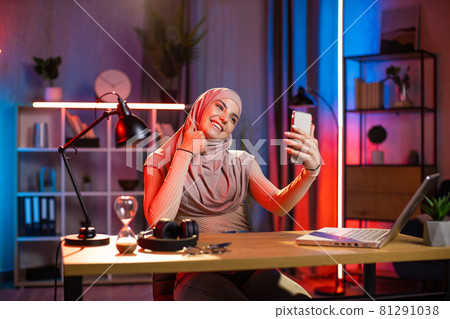 Muslim woman taking selfie on smartphone at home office 81291038