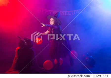 Funny child girl in witch costume for Halloween with pumpkin Jack. 81291351