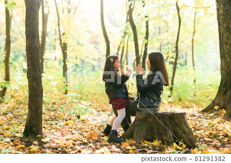 Little girl playing with mother in the autumn park 81291382