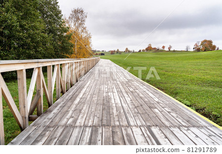 Autumn colorful trees and wooden paved walk landscape. Fall nature background. Great wallpaper design. Autumn colorful trees and wooden paved walk landscape. Fall nature background. Great wallpaper design. 81291789