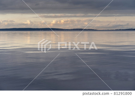Beautiful autumn misty grey lake and cloudy sky reflection in the water at sunset. Dark and moody nature background. Great wallpaper design. Copy space. Beautiful autumn misty grey lake and cloudy sky reflection in the water at sunset. Dark and moody nature background. Great wallpaper design. Copy space. 81291800