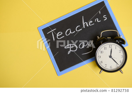 Flat lay composition from an alarm clock and chalkboard on yellow background with space for text. Teacher's Day 81292738