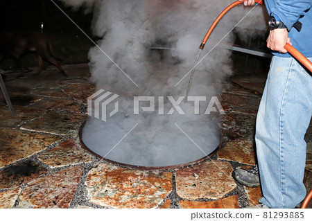 Putting out a campfire with water at the end of the night 81293885