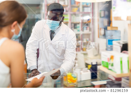 Pharmacist standing behind counter and talking with client 81296159