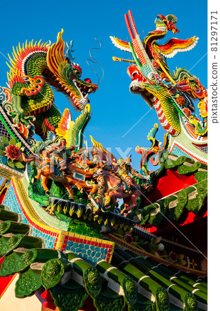 Incredible colorful Chinese figurines of Dragons, Phoenix and some Chinese warriors on top of green roof. 81297171
