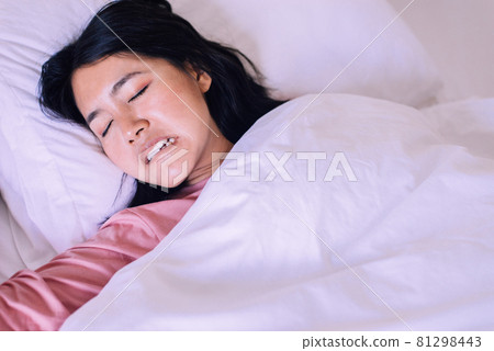 Asian woman sleeping and grinding teeth in bedroom,Female tiredness and stress 81298443