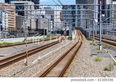 Commuter train tracks extending to the city center where skyscrapers are built 81300386