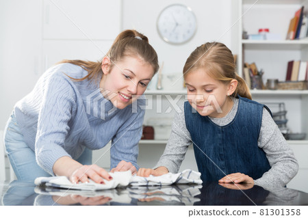 Woman with vacuum cleaner and daughter with rag Woman with vacuum cleaner and daughter with rag 81301358