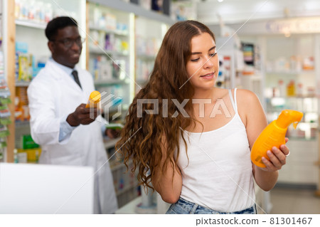 Young woman who came to the pharmacy chooses a hair care remedy 81301467