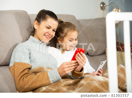 Mom and small daughter using smartphone in home 81301557