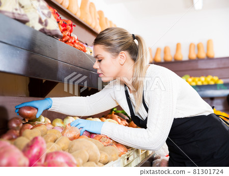 seller in gloves working with vegetables 81301724