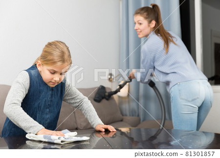 Woman with vacuum cleaner and daughter with rag Woman with vacuum cleaner and daughter with rag 81301857