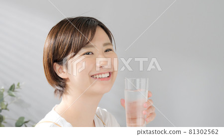 Young woman drinking water in the morning Young woman drinking water in the morning 81302562