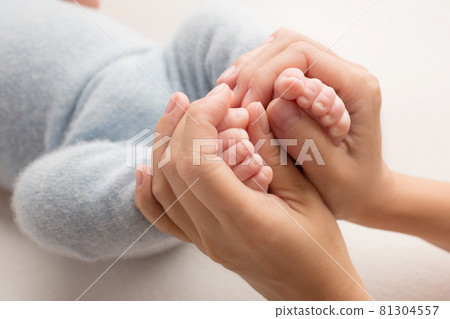 photo with children's legs that are held in the palms of mom and dad. family album. newborn feet. photo with children's legs that are held in the palms of mom and dad. family album. newborn feet. 81304557