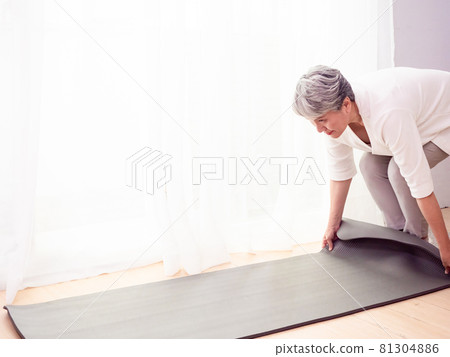 熟齡亞洲婦女在家在瑜伽墊上鍛鍊保健 81304886